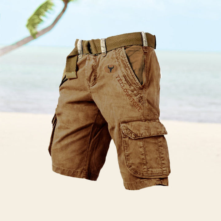 Male model wearing versatile knee-length shorts with utility styling on a plain background.
