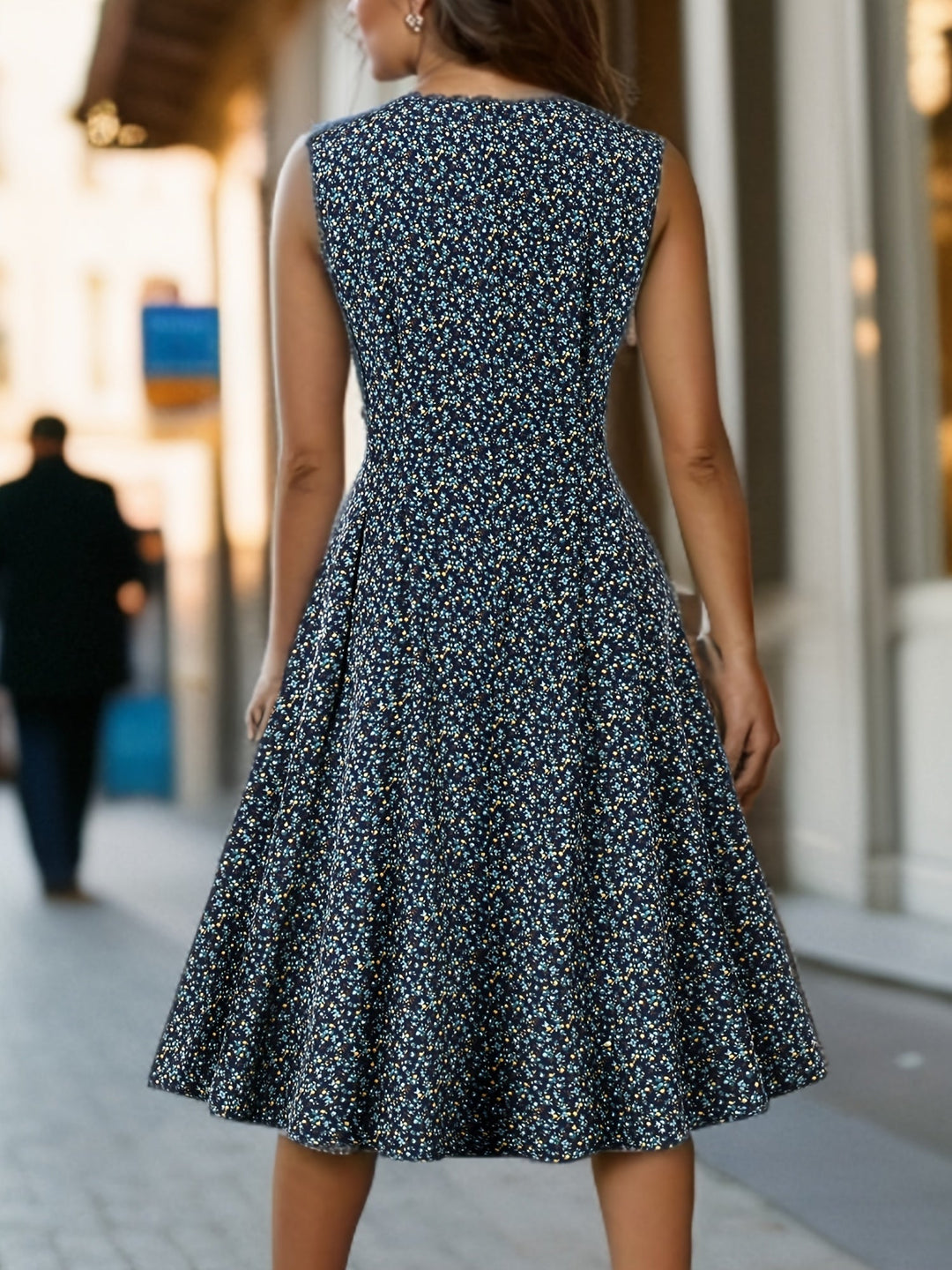  Female model in a lightweight floral dress with a flared skirt against a plain background.