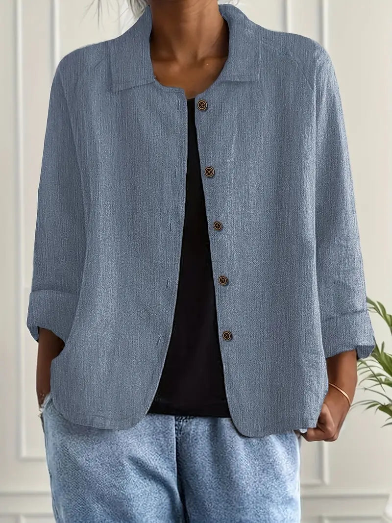 Woman in a soft breathable top on a plain background with a polished casual style.