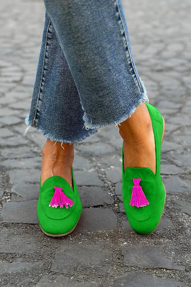Female wearing tassel loafers displayed on a plain background.