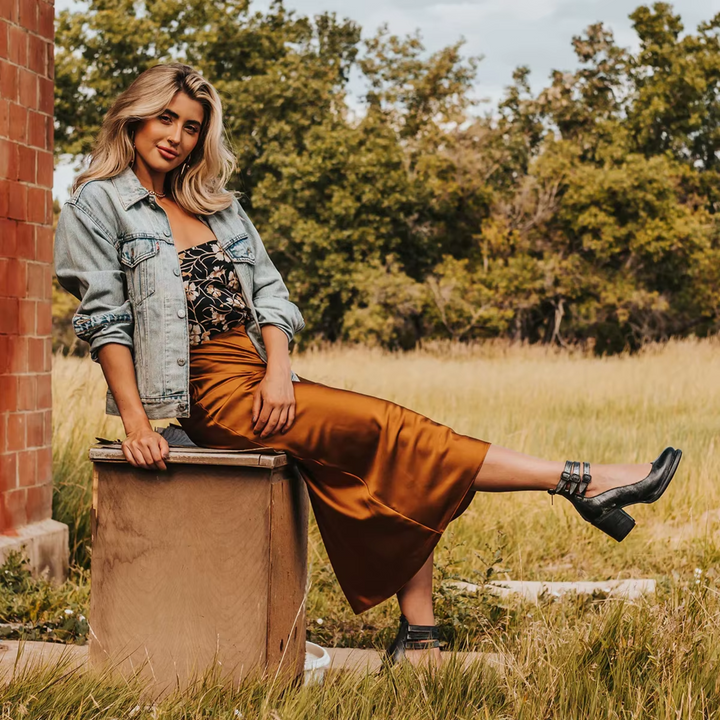 Woman’s showcasing the modern dress and heels sandal on nature background.