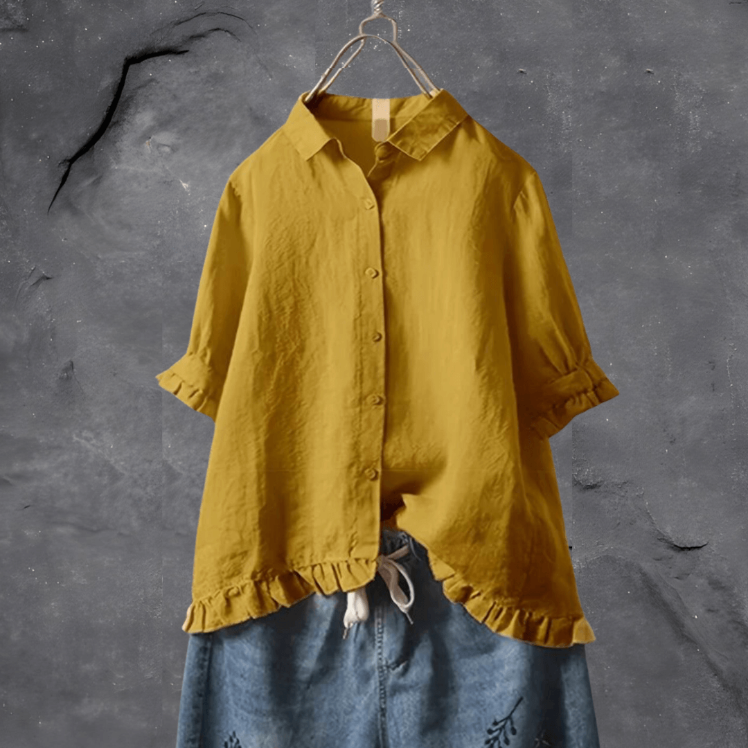 Sophisticated women’s blouse displayed on a plain background with subtle detailing and airy comfort.