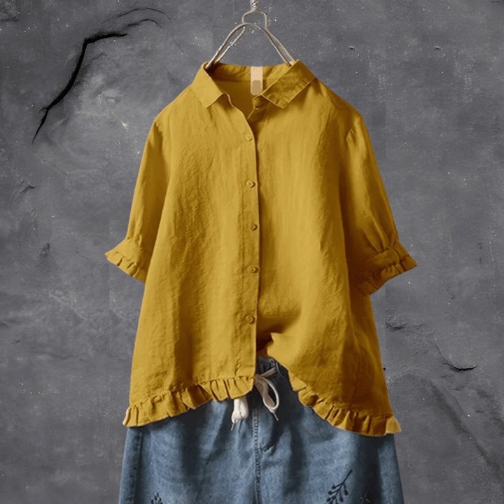 Sophisticated women’s blouse displayed on a plain background with subtle detailing and airy comfort.