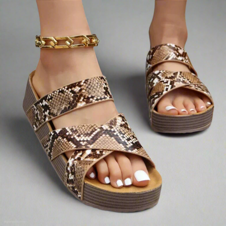 Foot wearing breathable sandal on plain studio background.