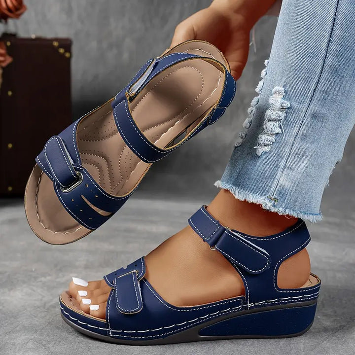Foot wearing supportive wedge sandal for everyday comfort.