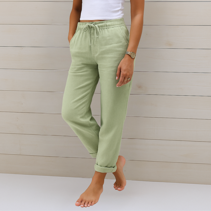 Woman wearing refined everyday trousers on a plain background.
