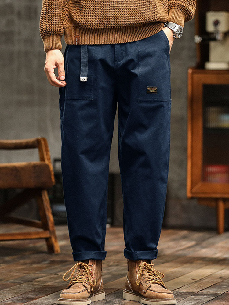  Male model showcasing wide-leg cargo trousers with rolled cuffs on a plain background.