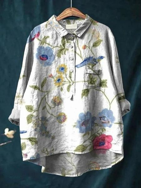 Graceful floral blouse against a plain background.