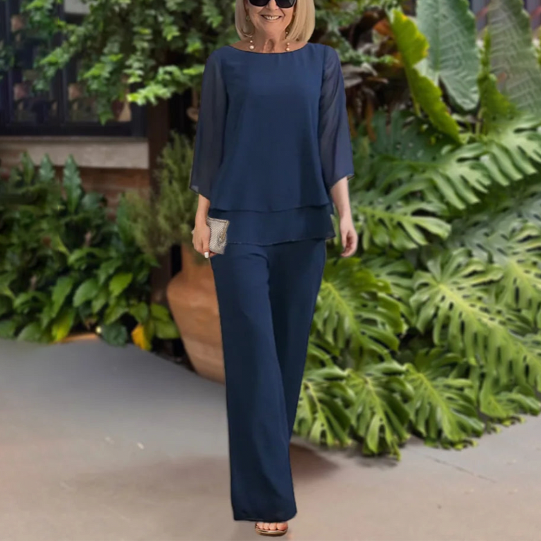  Woman in a matching summer top and trouser set on a plain background.