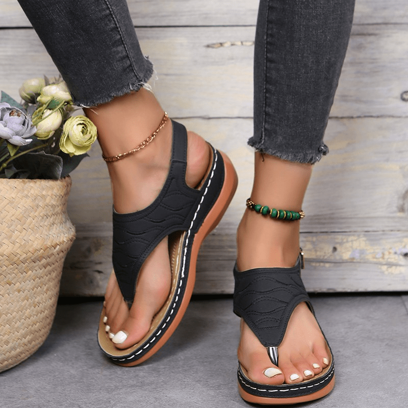 Female model wearing stylish cushioned sandals on a plain background.