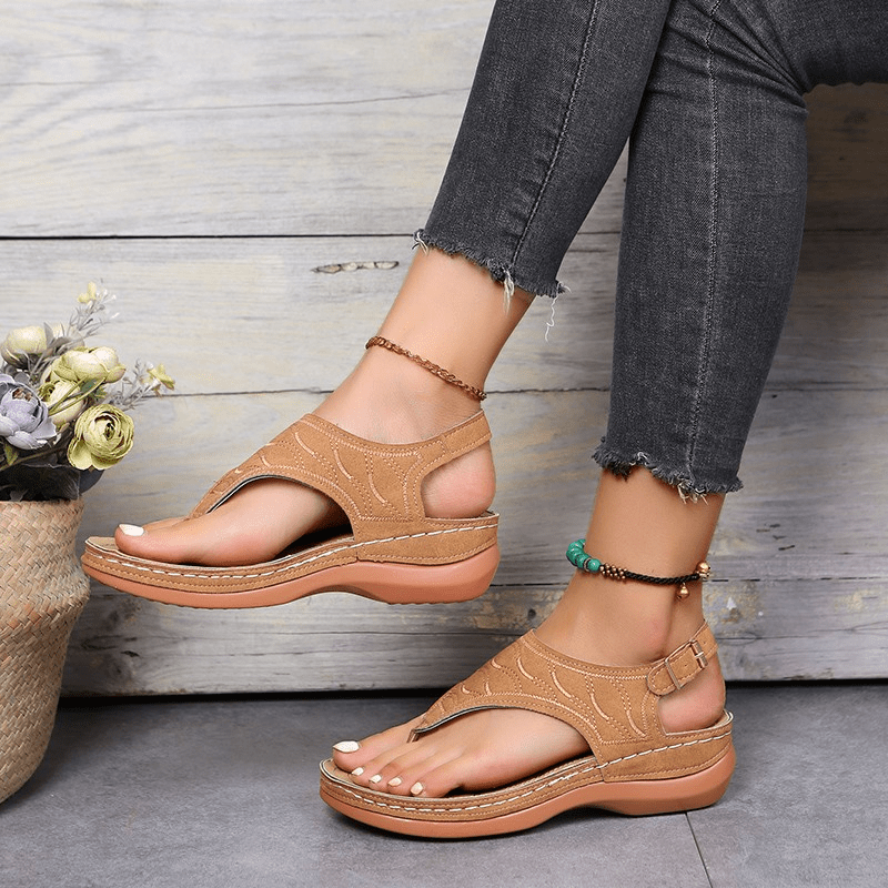 Woman wearing graceful strappy sandals suitable for casual wear on a plain background.