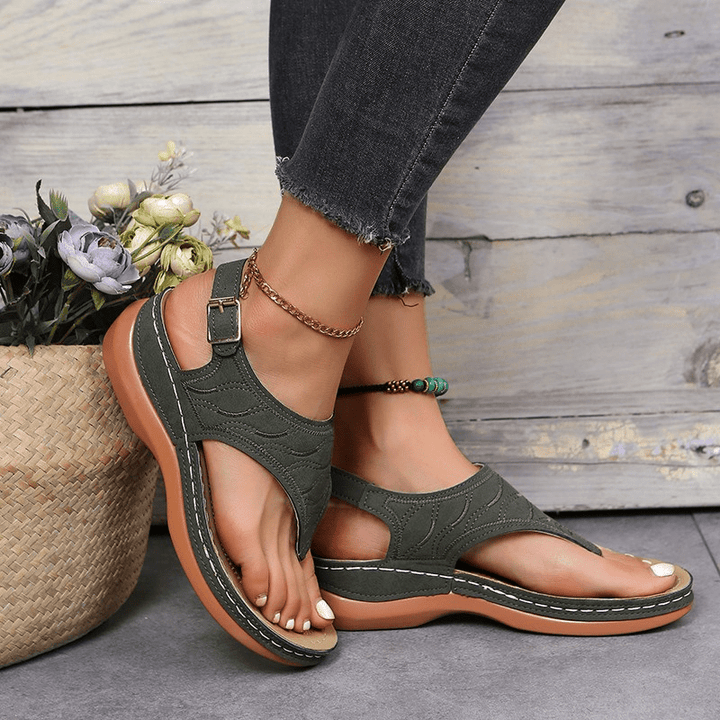 Female model wearing dressy comfort sandals on a plain background.
