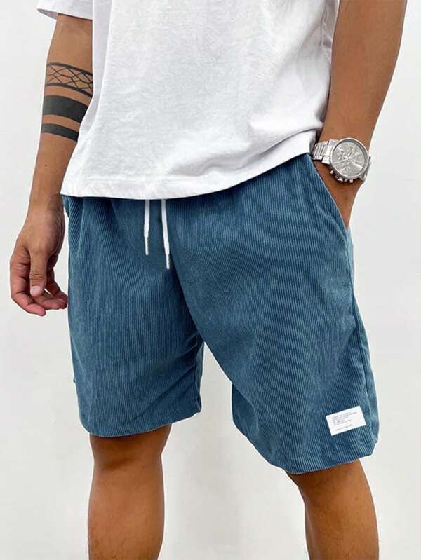 Male model wearing casual drawstring shorts against a plain background.