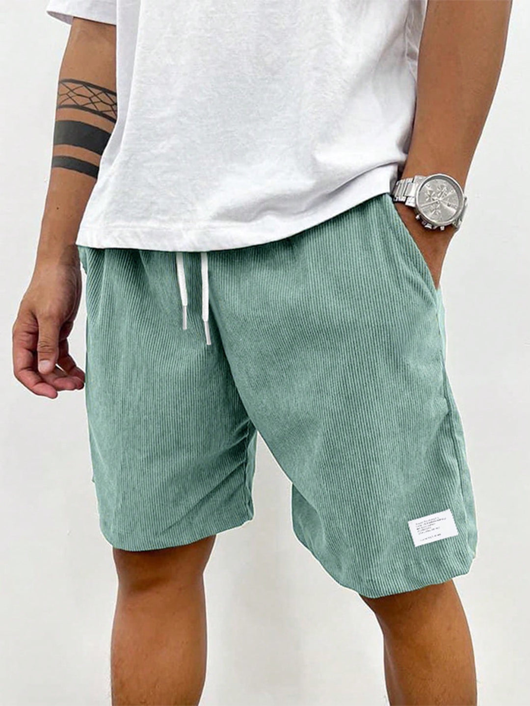  Male model in relaxed summer shorts with pockets on a plain background.
