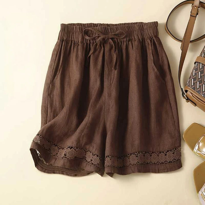 Lightweight embroidered shorts shown on a neutral beige background.