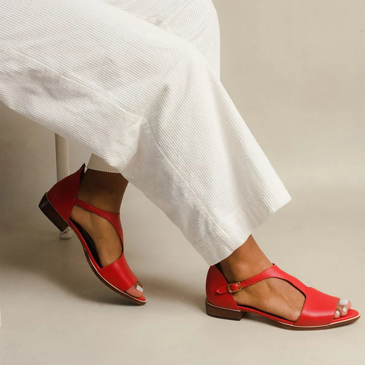 Women’s open-low flat sandals on a plain background with a refined slip-on design.