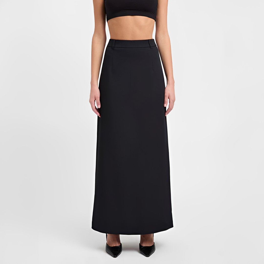 Female wearing a flowing maxi skirt paired with a fitted top against a plain background.
