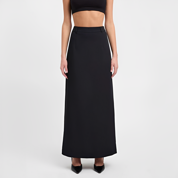 Female wearing a flowing maxi skirt paired with a fitted top against a plain background.