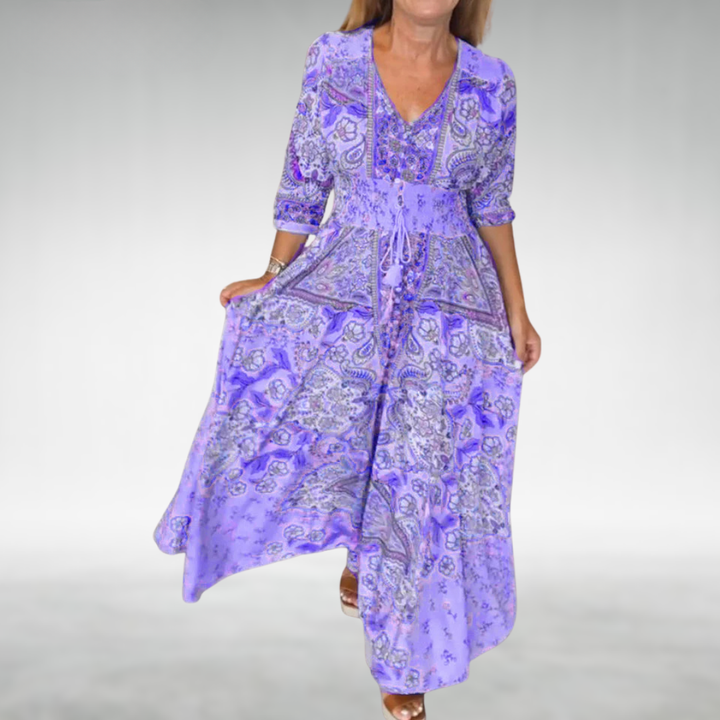 Flowing bohemian maxi dress on plain background with soft draped silhouette.