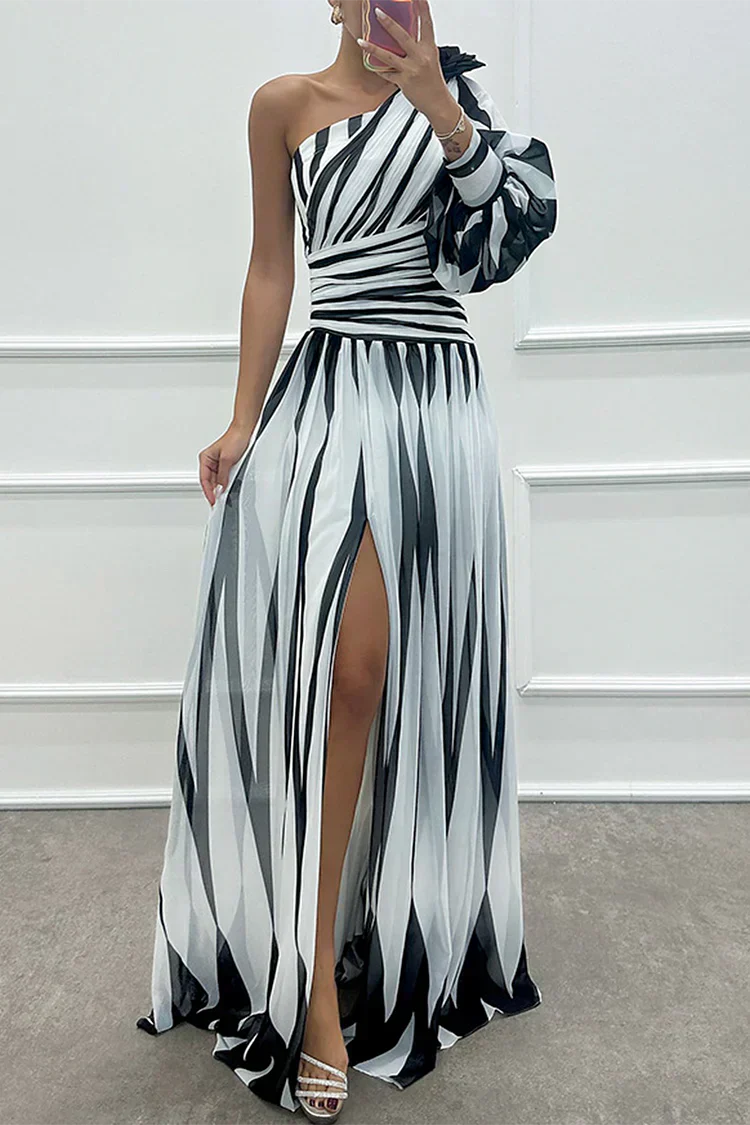 Female model in a flowing striped maxi dress on a clean background.