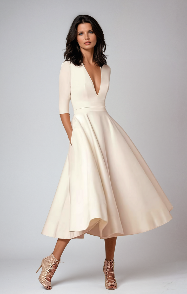 Woman wearing flared midi dress standing in living room setting