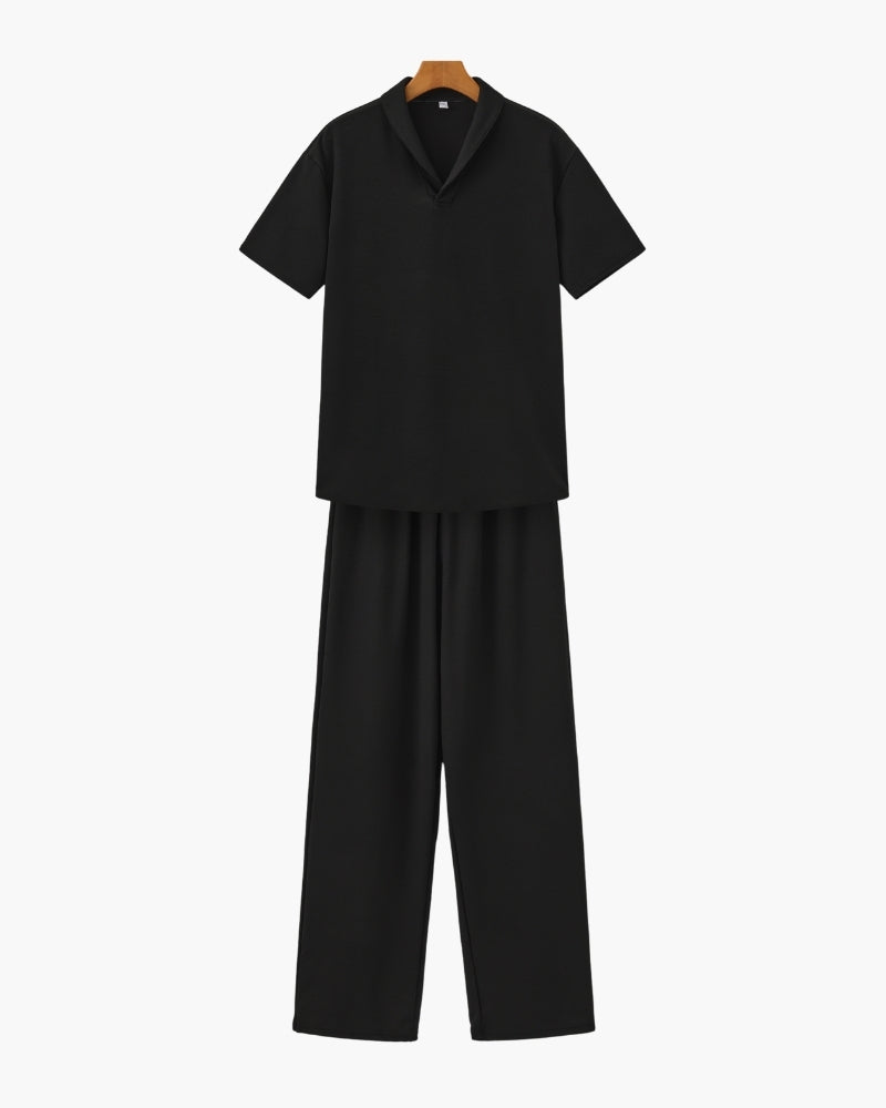 A casual short sleeve V-neck shirt and matching pants on a plain background.e