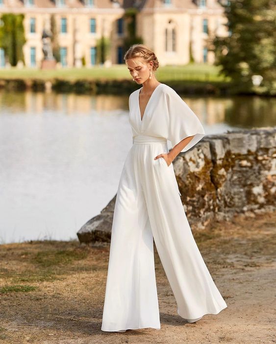 Female model wearing a wide-leg kimono sleeve jumpsuit against a plain background.