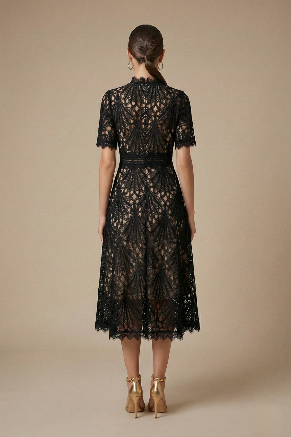 Woman modeling a lace midi dress featuring intricate lace detailing and an A-line skirt on a plain background.