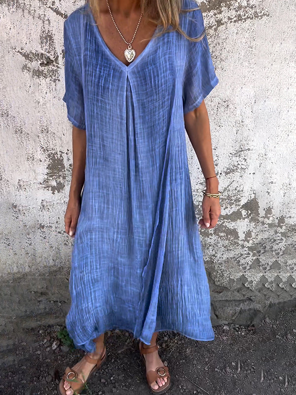 Female model wearing a flowing maxi dress against a plain background.