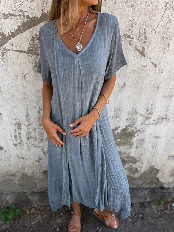 Woman wearing a sleeveless flowing dress with a flattering silhouette.