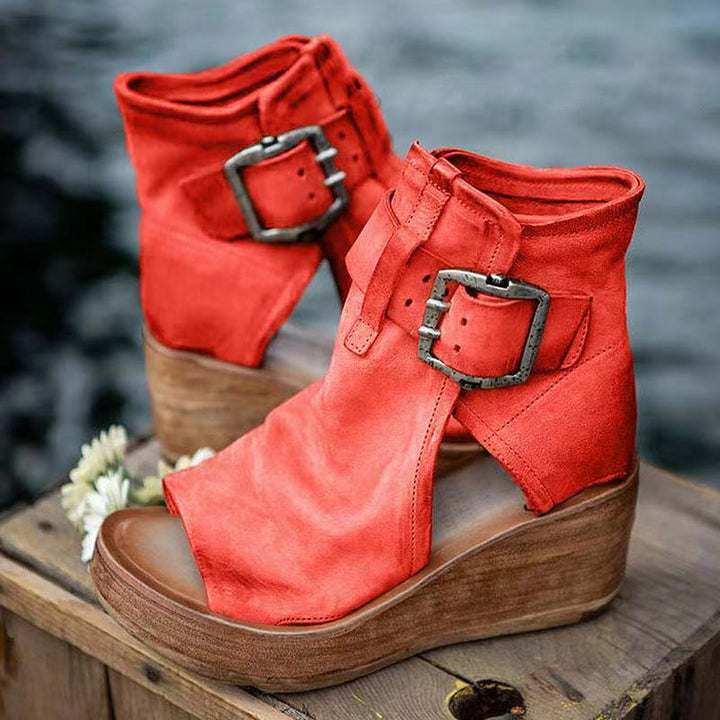 Open-toe wedge sandals with secure buckle closure on a plain background.