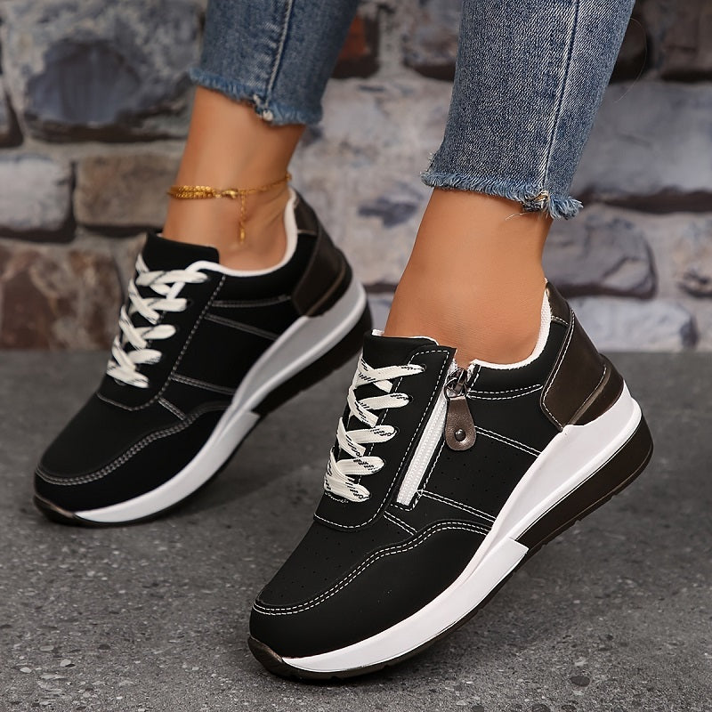 Female feet shown in casual lace-up sneakers on a plain background.