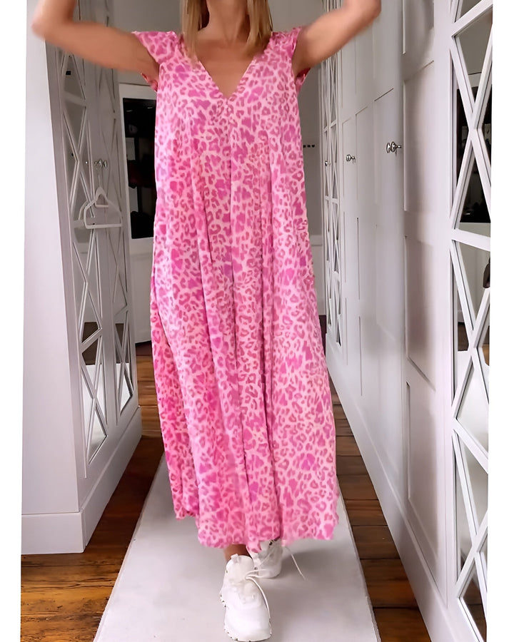 Female model wearing a V-neck leopard print long dress on a plain background.