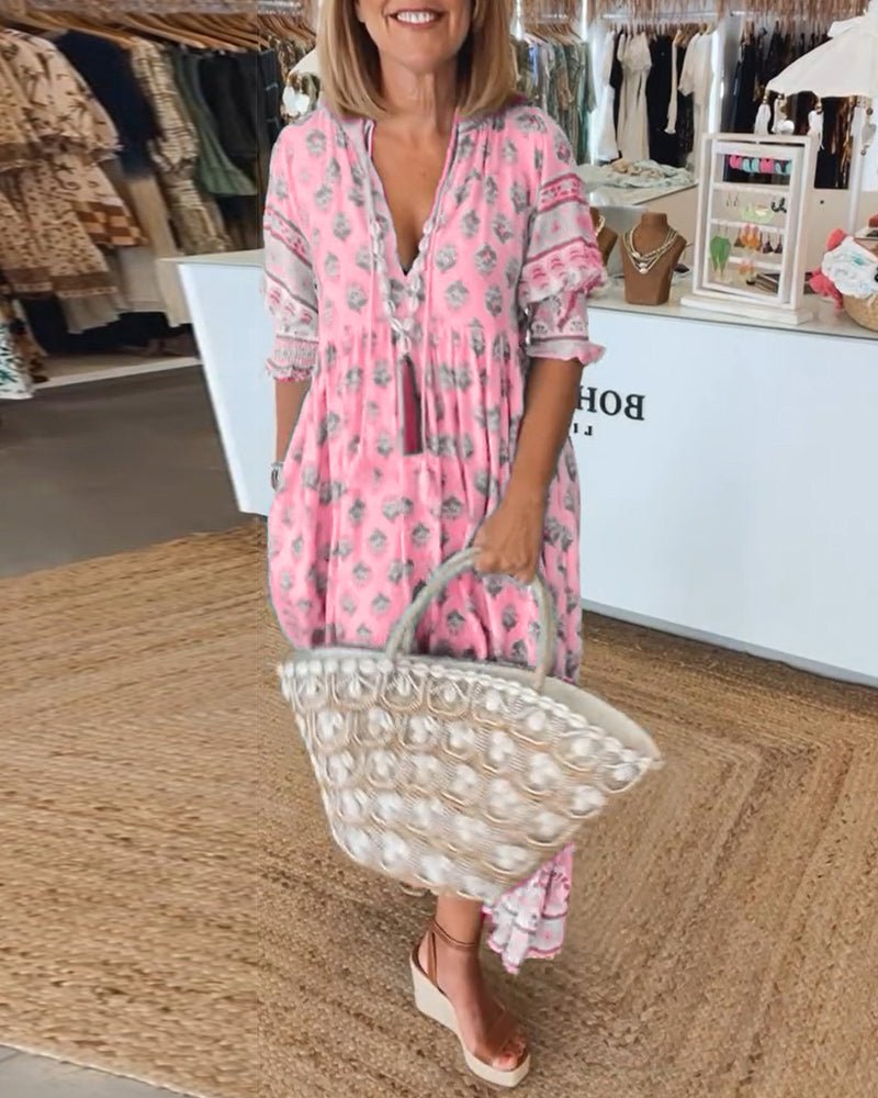 Casual boho dress shown on a plain background with breezy movement and tassel trim.