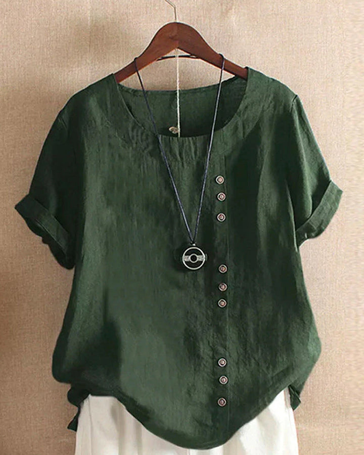 Minimalist linen blouse front lay on the hanger on plain background.