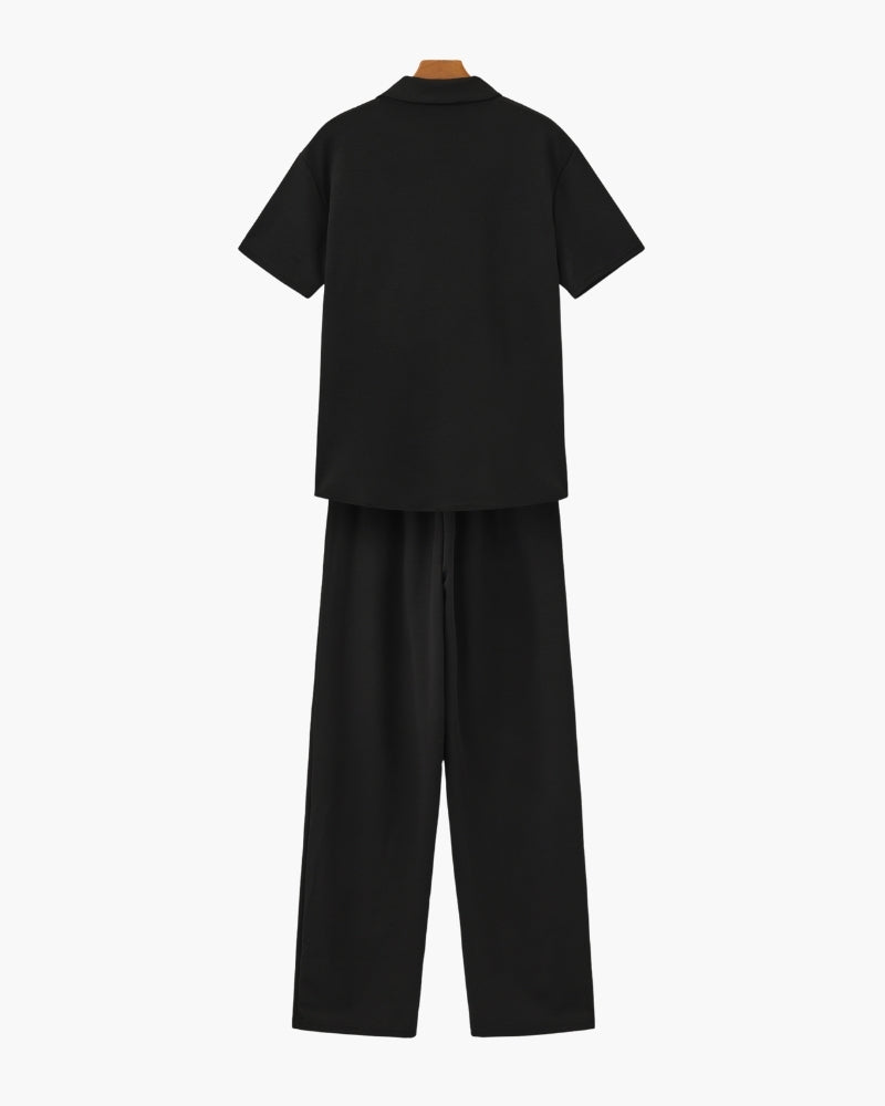 A relaxed two-piece outfit with a V-neck top and loose pants on a plain background.