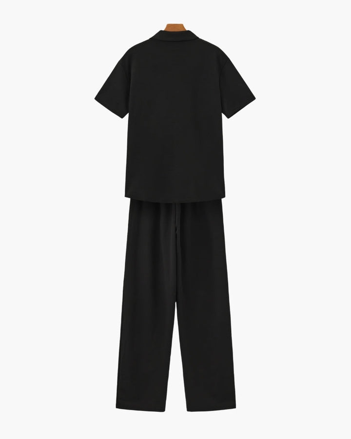 A relaxed two-piece outfit with a V-neck top and loose pants on a plain background.