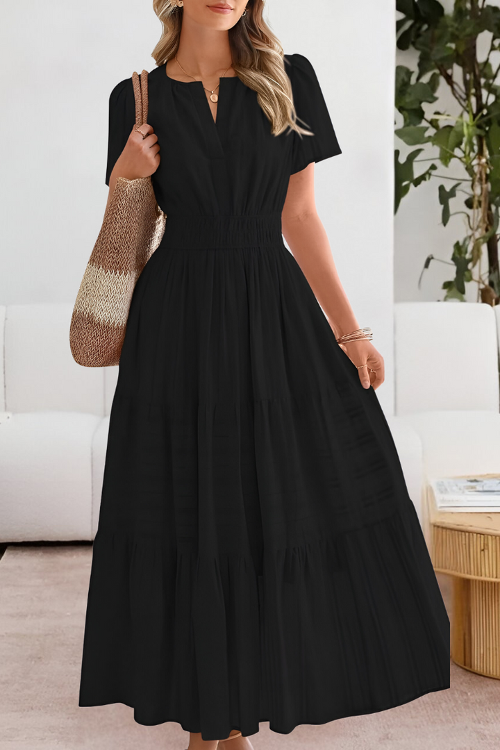 Woman posing in a lightweight summer dress with a relaxed fit on a plain background.