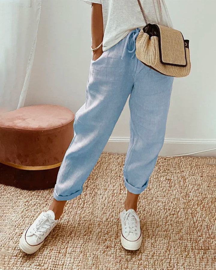 Woman in lightweight waistband pants against a plain background.