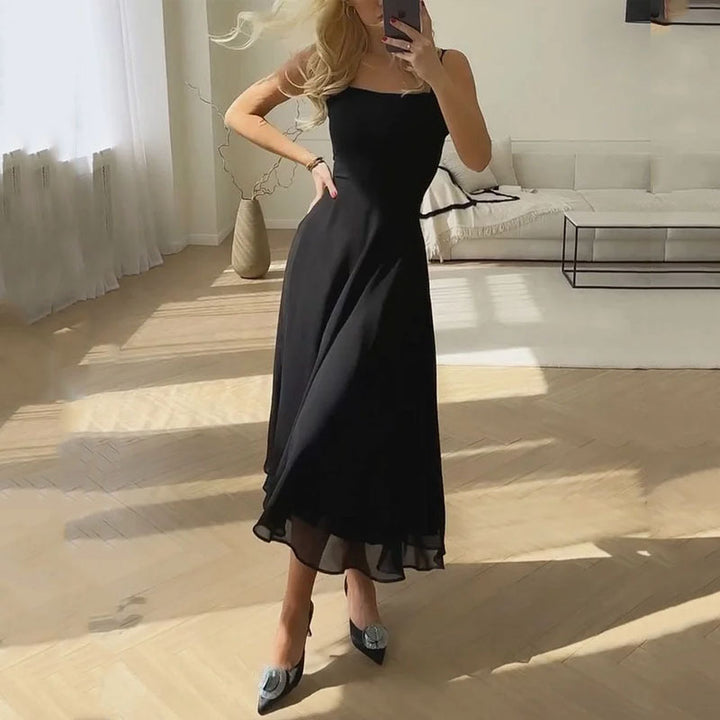 Female model standing indoor wearing flowing midi dress soft breeze