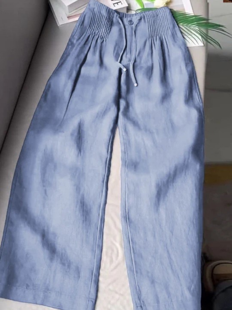 Female wearing wide-leg pants on a plain background for a clean fashion look.