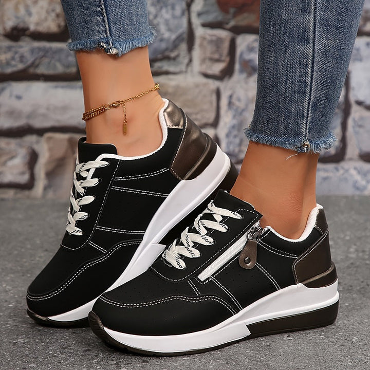 Woman standing in lightweight everyday sneakers on a plain background.