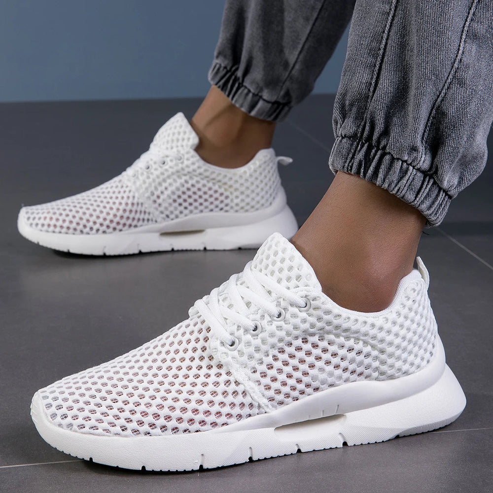 Woman wearing breathable casual sneakers against a plain background.