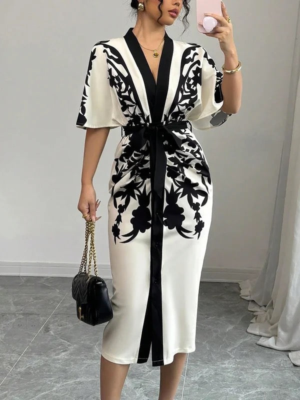 Female wearing a floral print midi dress with batwing sleeves and a button-front design on a plain background.
