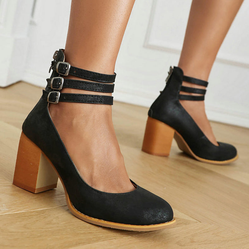 Close-up of a foot in an ankle strap block heel sandal on a clean background.