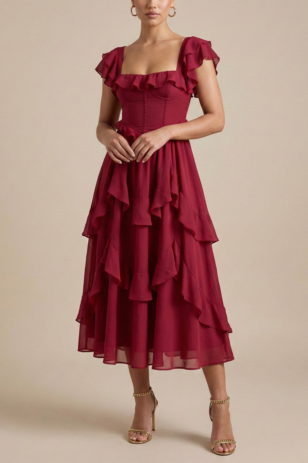 Female model wearing a layered ruffle midi dress with flutter sleeves on a plain background.