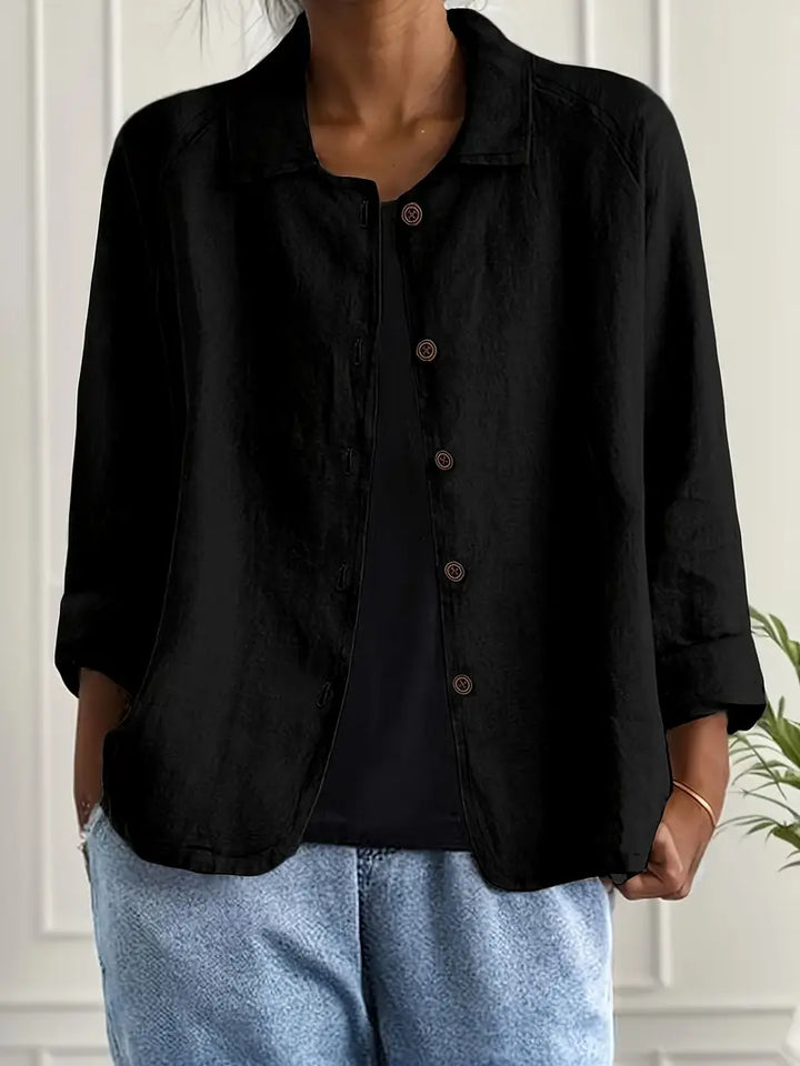 Lightweight top worn on a plain background with a smooth draped fit and refined appeal.