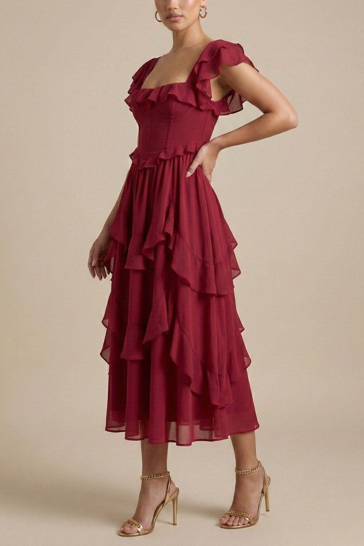 Female model showcasing a ruffle neckline midi dress with a defined waist on a plain background.