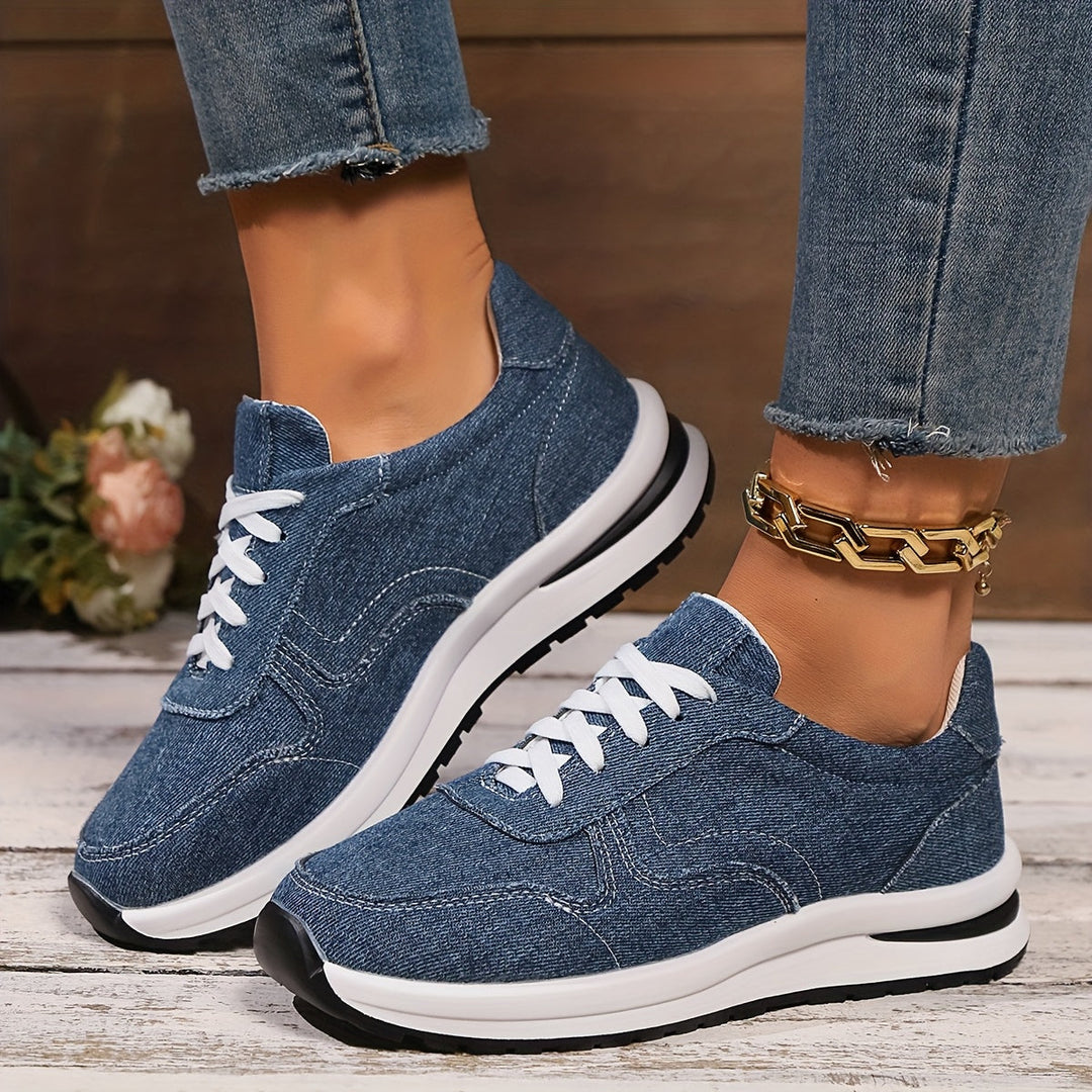 Women’s denim-inspired sneakers on a plain background with a casual everyday look.