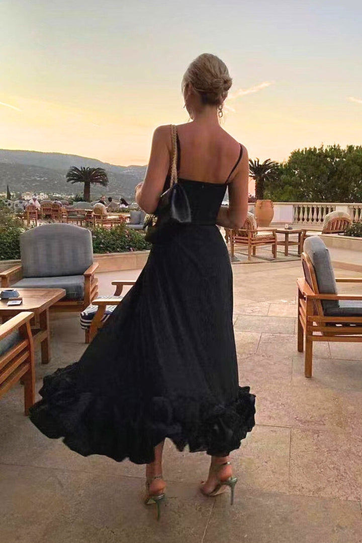 Model showcasing a soft flowing dress with a plain backdrop, back view